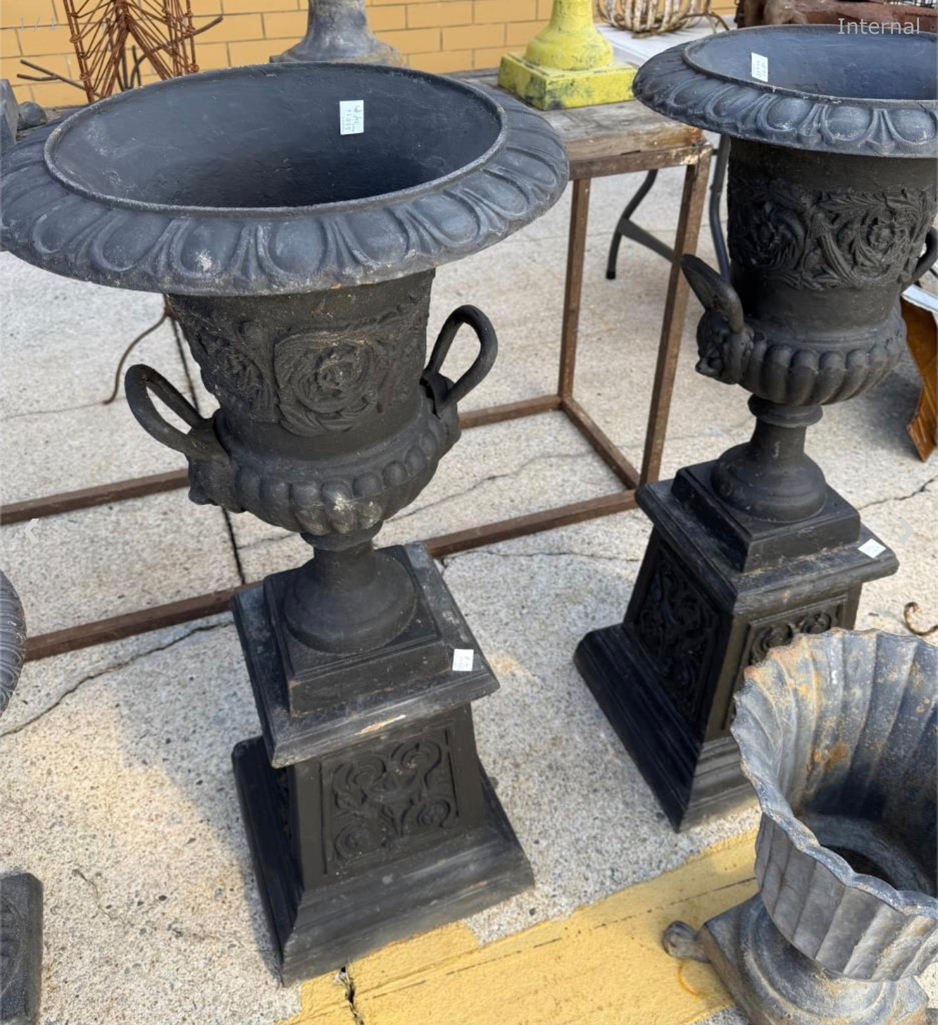 Pair of cast iron urns on stands