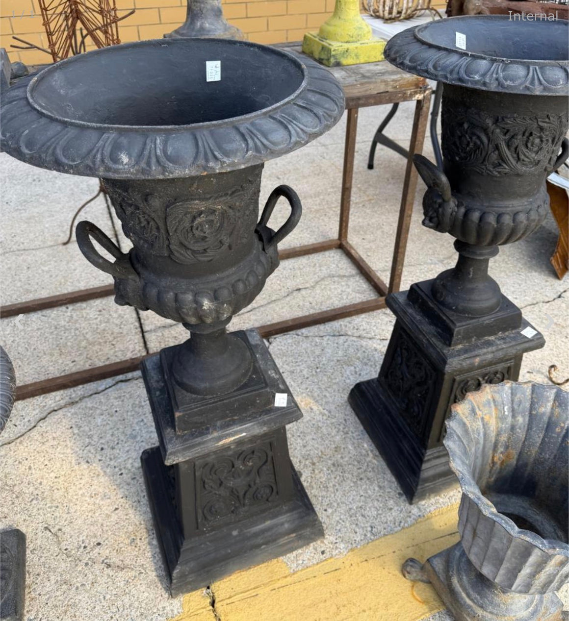 Pair of cast iron urns on stands
